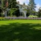 White house with flower garden and green lawn.